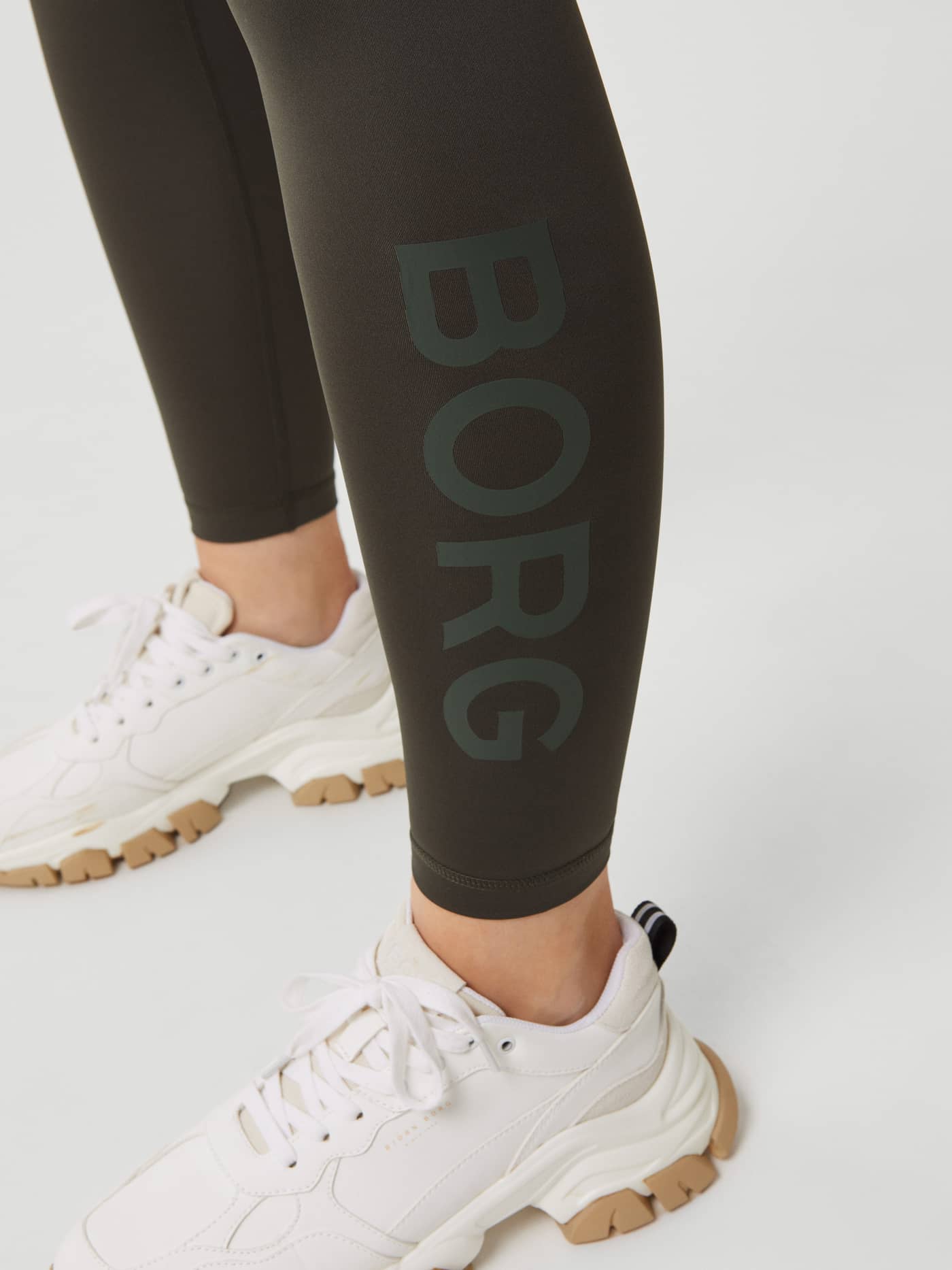 Close-up of the Peat (Green) Borg Logo Tights for training, highlighting the tonal BORG logo and performance fit. - Image 4
