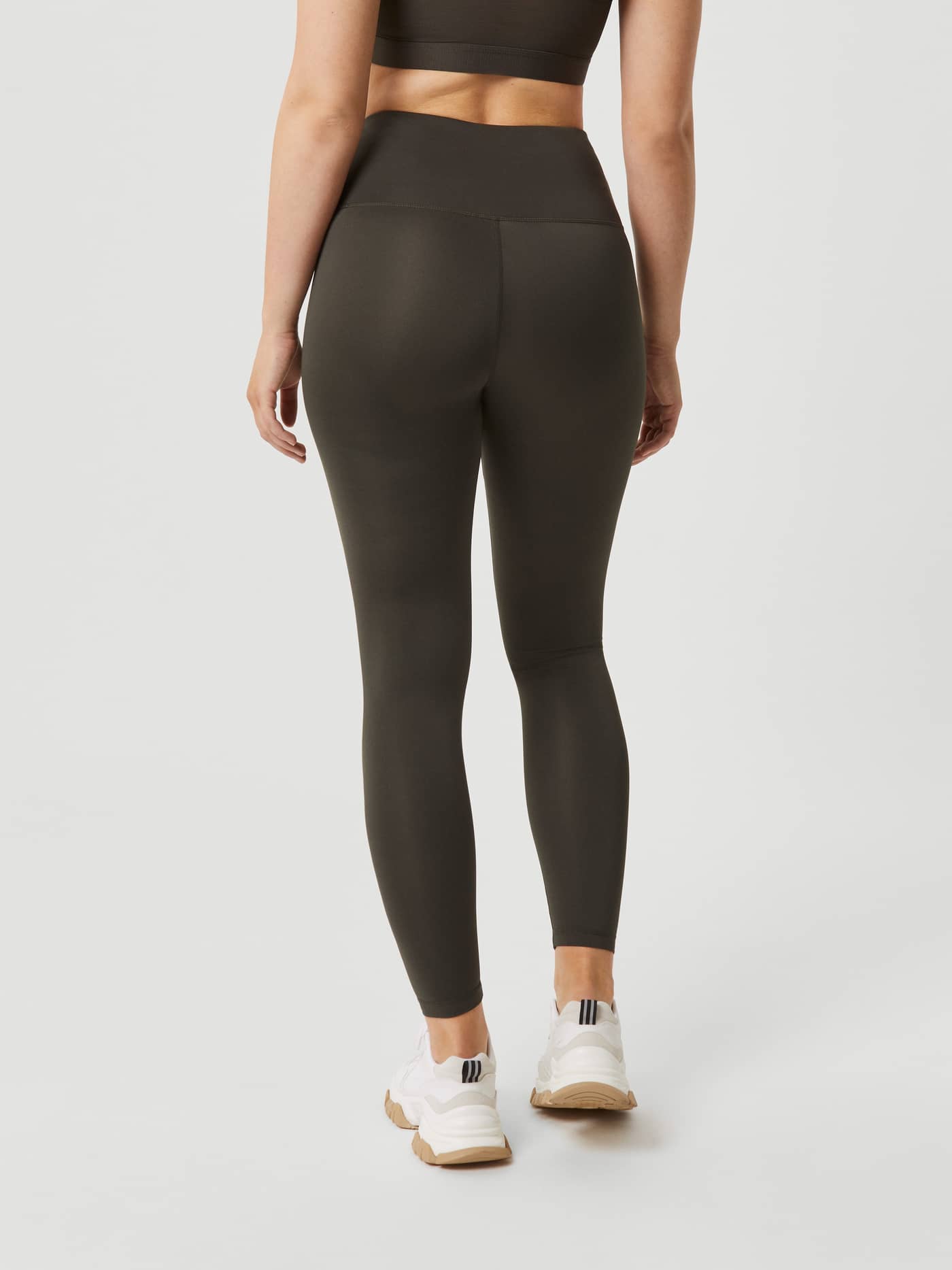Back view of a woman wearing high-waisted Borg Logo Tights in Peat (Green), designed for a stylish training fit. - Image 3