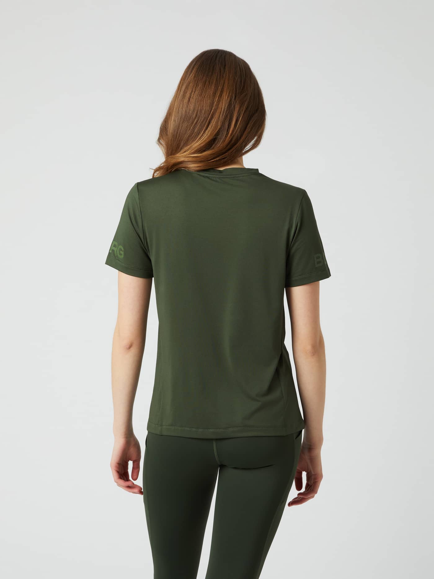 Back view of a woman wearing the Duffel Bag (Green) Borg T-Shirt, a training top with a regular fit and tonal sleeve logos. - Image 2