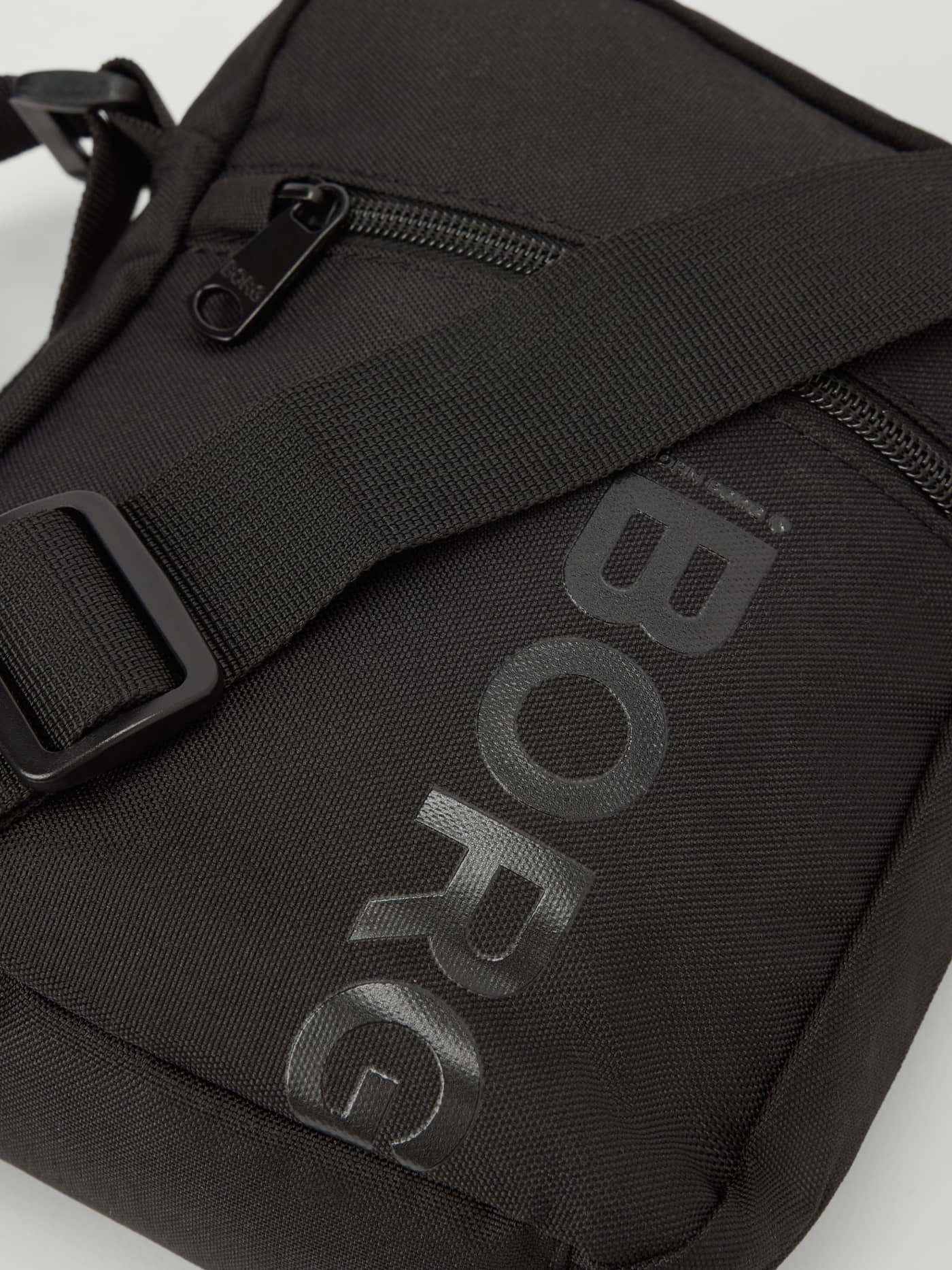 Detailed close-up of the Core Crossover Bag 1,7L in Black Beauty (Black) with a large tonal BORG logo and zipper. - Image 3