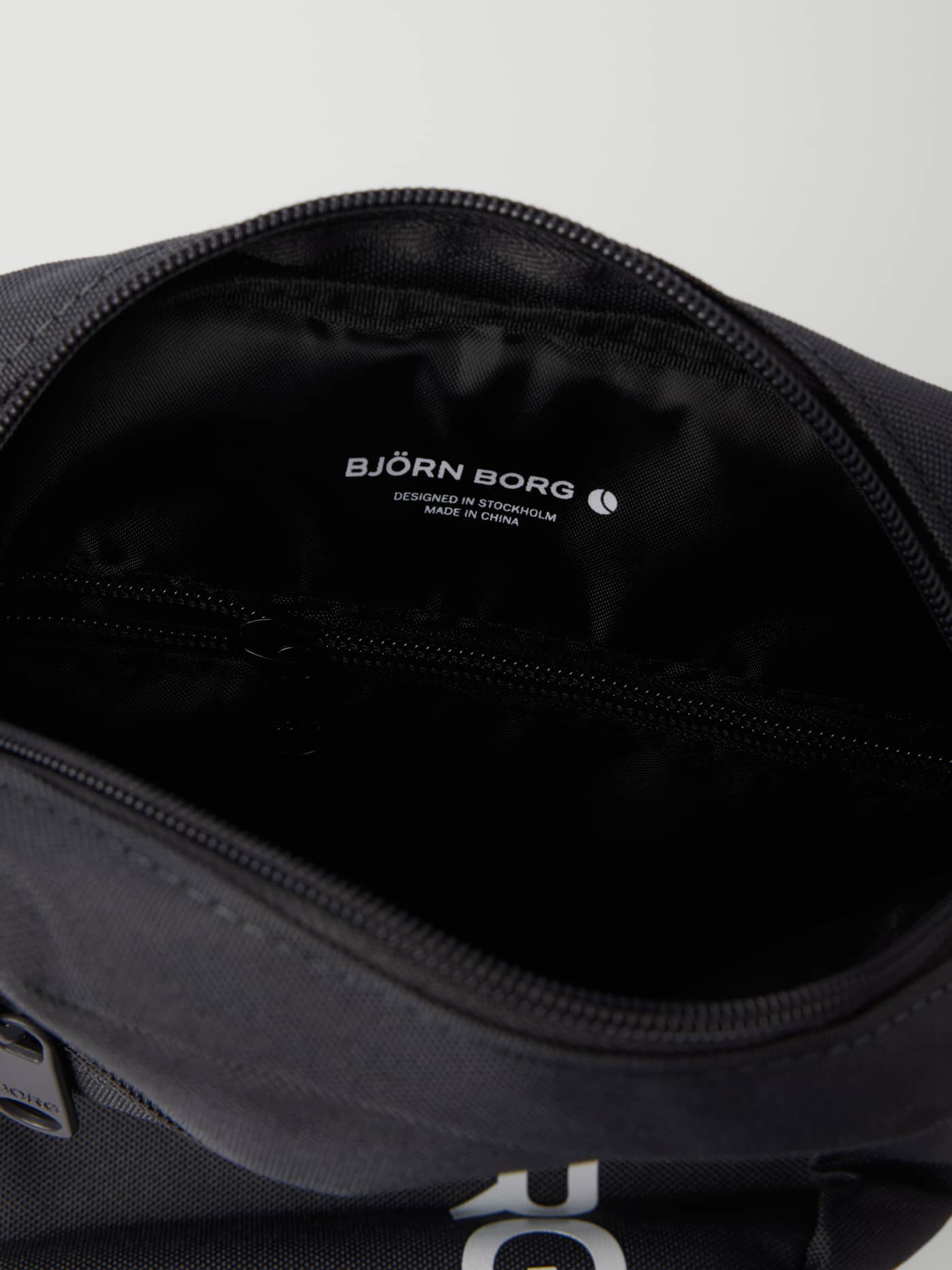 Björn Borg Core Crossover Bag 1,7L in Asphalt (Grijs) van binnen gezien met een ritsvak en wit logo. - Image 3