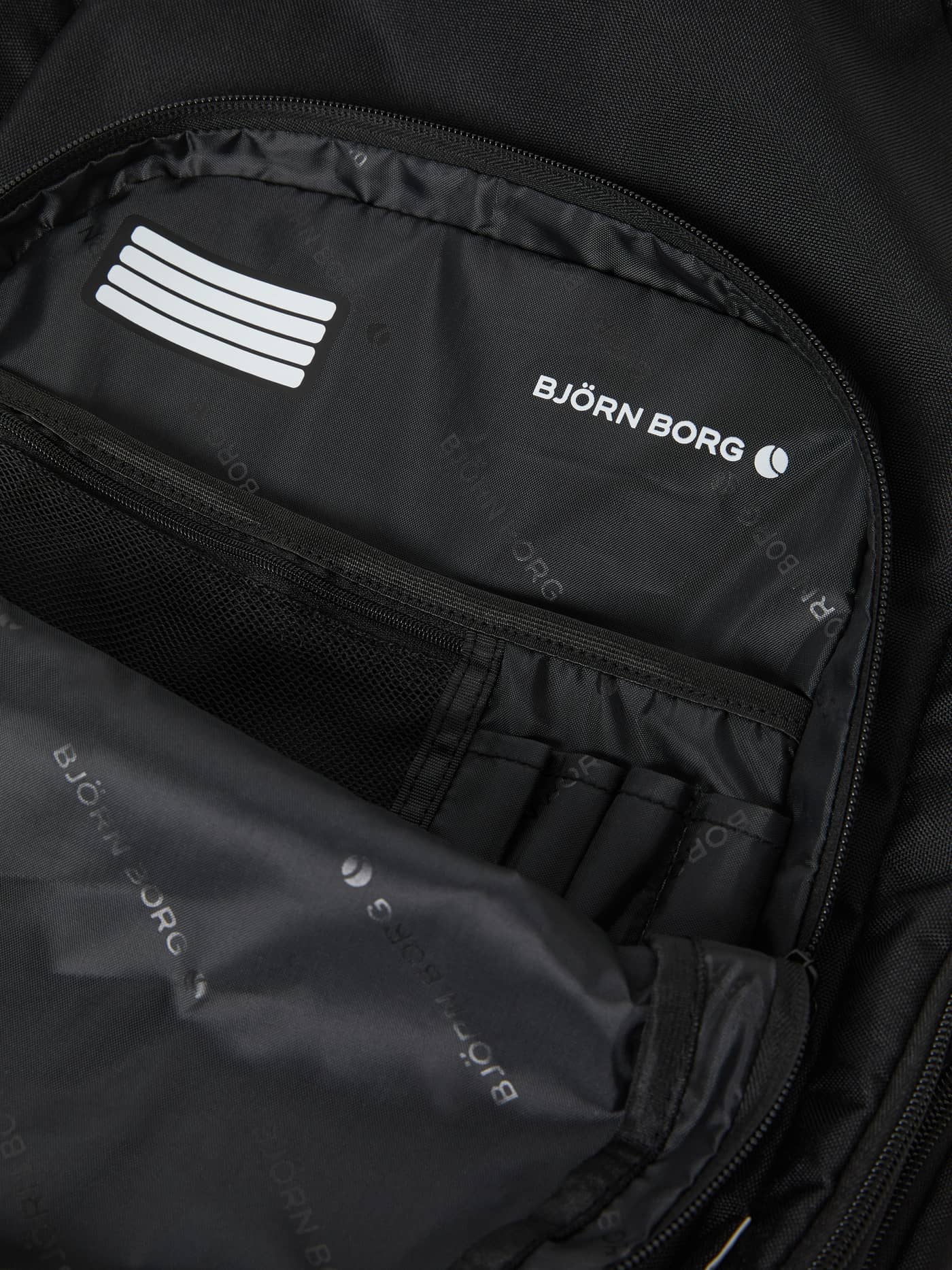 Intérieur du Core Curve Backpack 27L en Black Beauty (Noir) avec compartiments organisés et logo Björn Borg blanc. - Image 7