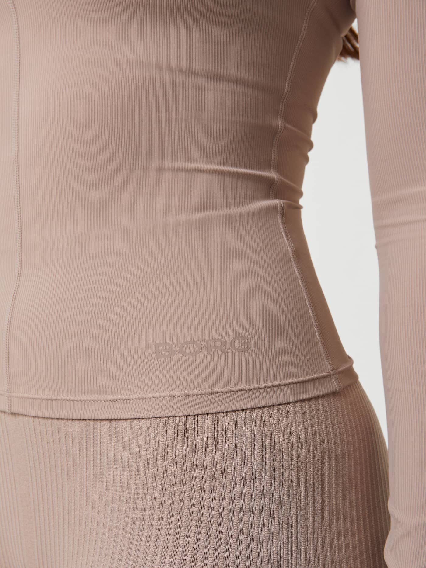 Close-up van de Studio Ballerina Long Sleeve in Etherea (Beige), een slim-fit trainingstop met bijpassend BORG-logo. - Image 5