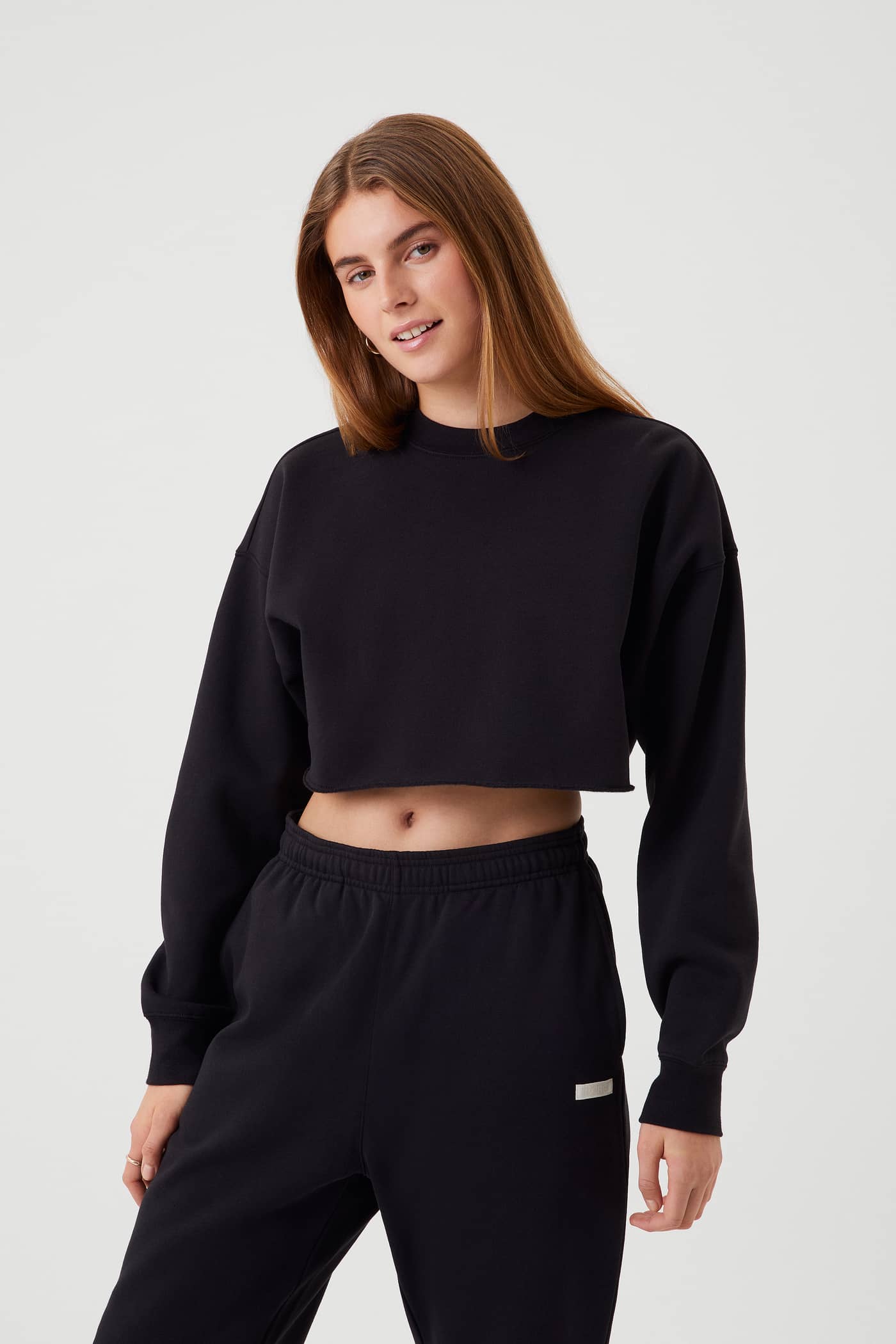 Front view of a woman in the Björn Borg Studio Oversized Cropped Crew in Black Beauty (Black) with a stylish cropped fit. - Image 1