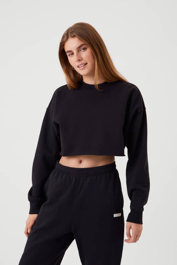 Front view of a woman in the Björn Borg Studio Oversized Cropped Crew in Black Beauty (Black) with a stylish cropped fit.