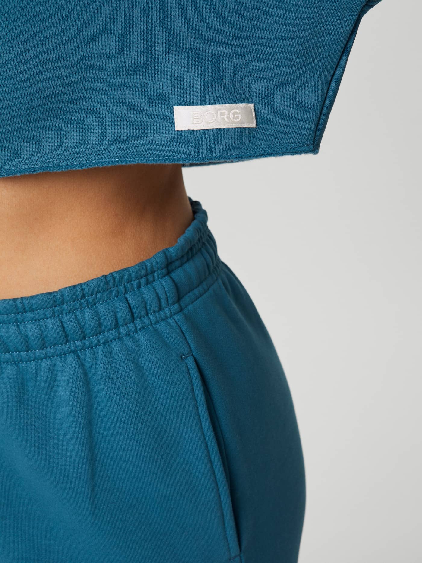Close-up of the Mallard Blue (Blue) Studio Oversized Cropped Crew showing the raw edges and white satin Borg logo label. - Image 5