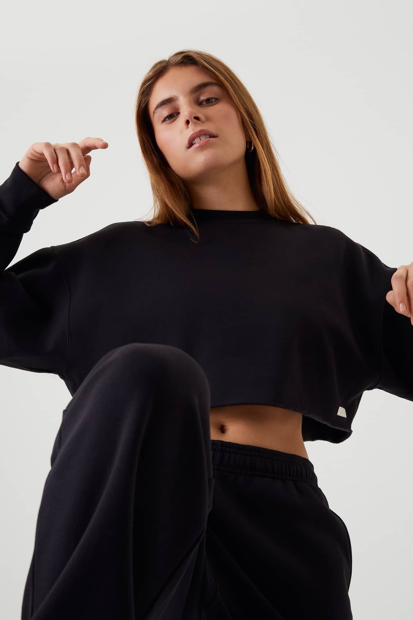 Untersicht eines Models im Björn Borg Studio Oversized Cropped Crew in Black Beauty (Schwarz) mit offenen Schnittkanten. - Image 4