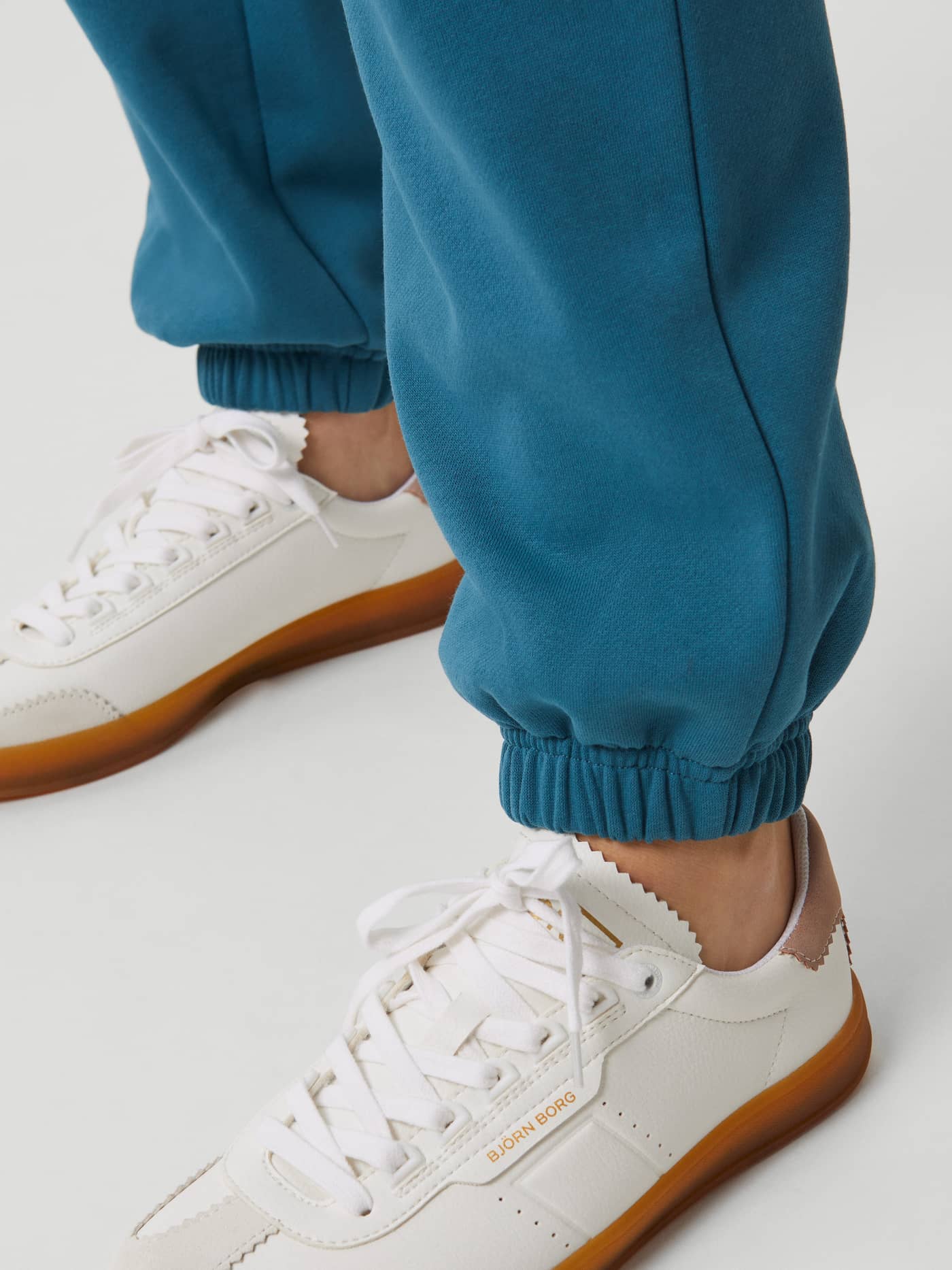 Detailed close-up of the ribbed cuffs on the women's Björn Borg Studio Oversized Pants in Mallard Blue (Blue). - Image 5