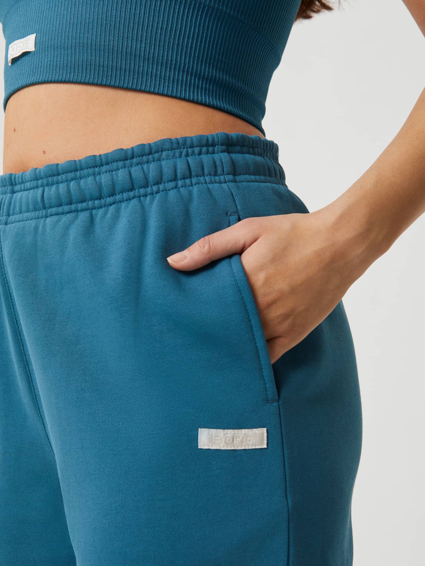 Close-up of Mallard Blue (Blue) Studio Oversized Pants showing the side pocket, ribbed waistband, and white BORG logo. - Image 4