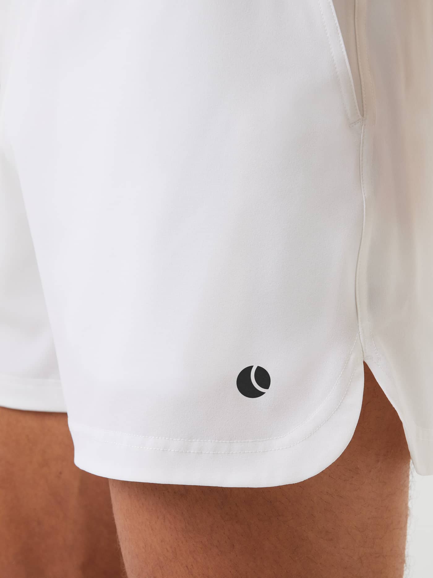 Close-up of the Björn Borg Ace Short Shorts in Brilliant White (White), featuring a side slit and black tennis ball logo. - Image 4