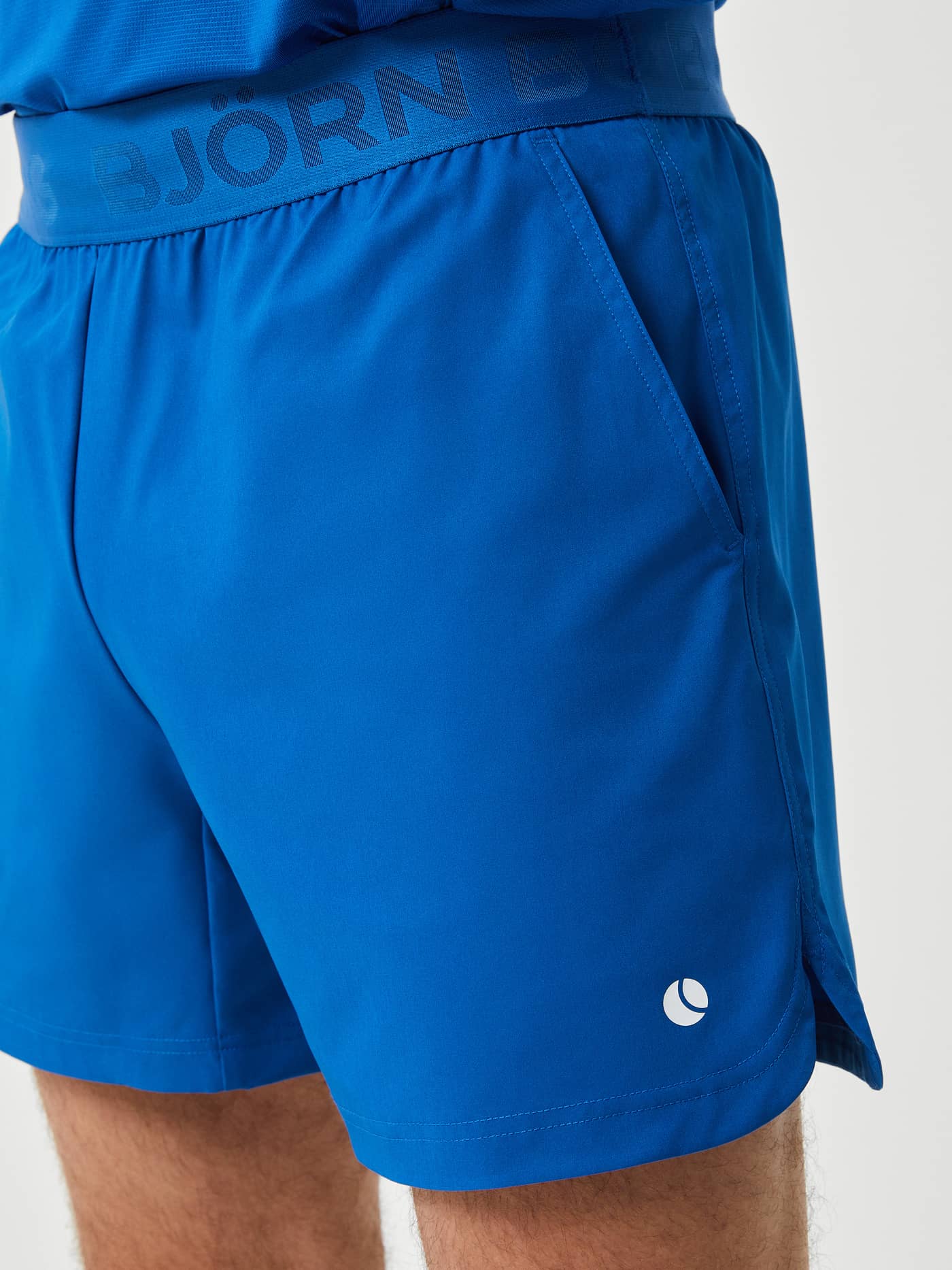 Ace Short Shorts i Classic Blue (Blå) för herr sedda från sidan med slitsar, perfekt för prestation på tennisbanan. - Image 3