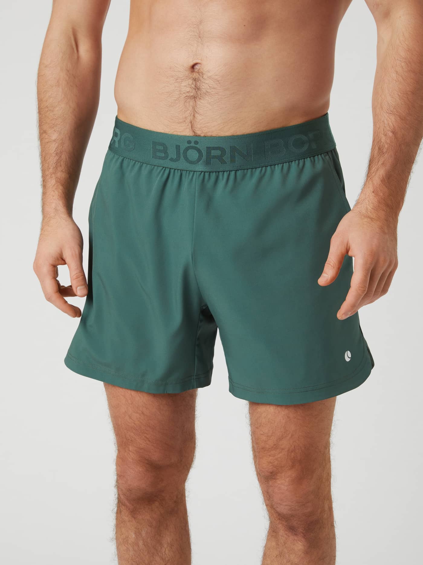 Front view of a man wearing the Björn Borg Ace Short Shorts in Cilantro (Green), designed for tennis performance. - Image 1