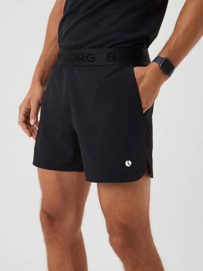 Ace Short Shorts i Black Beauty (Sort) set fra siden med et hvidt tennis-logo til performance og træning. - Image 4