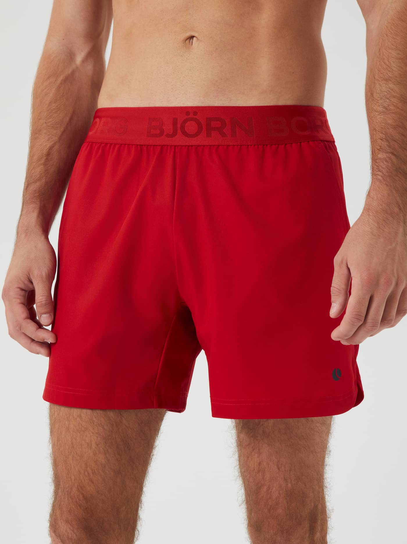 Front view of a man wearing the Björn Borg Ace Short Shorts in Samba (Red) with a branded waistband for tennis and training. - Image 2
