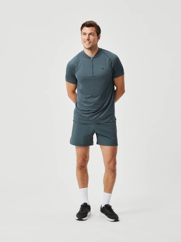 Full-body front view of a man in Björn Borg Ace Short Shorts in Urban Chic (Green) with a black logo for tennis training.