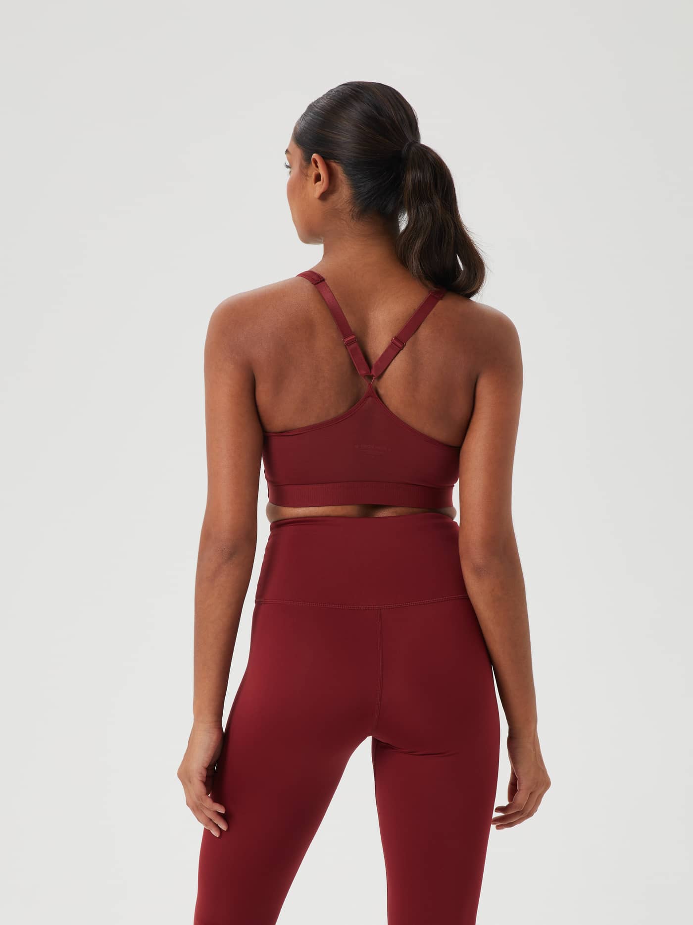 Achteraanzicht van model in de Pomegranate (Rood) Borg Mid V Support en bijpassende legging voor stijlvolle training. - Image 3