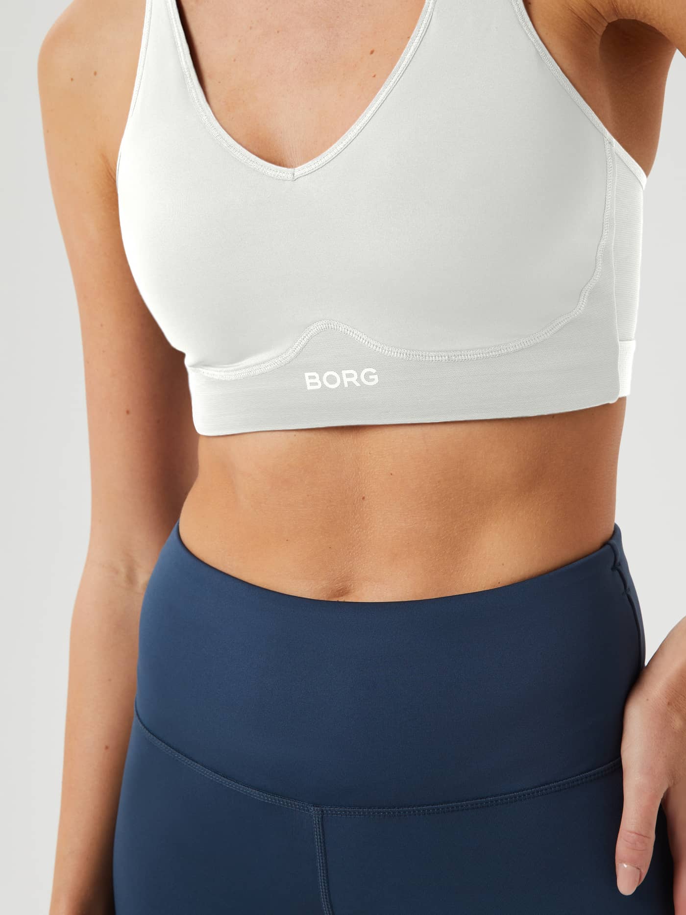 Borg Mid V Support in Egret (Wit), close-up vooraanzicht met logo en stijlvolle pasvorm voor training. - Image 3