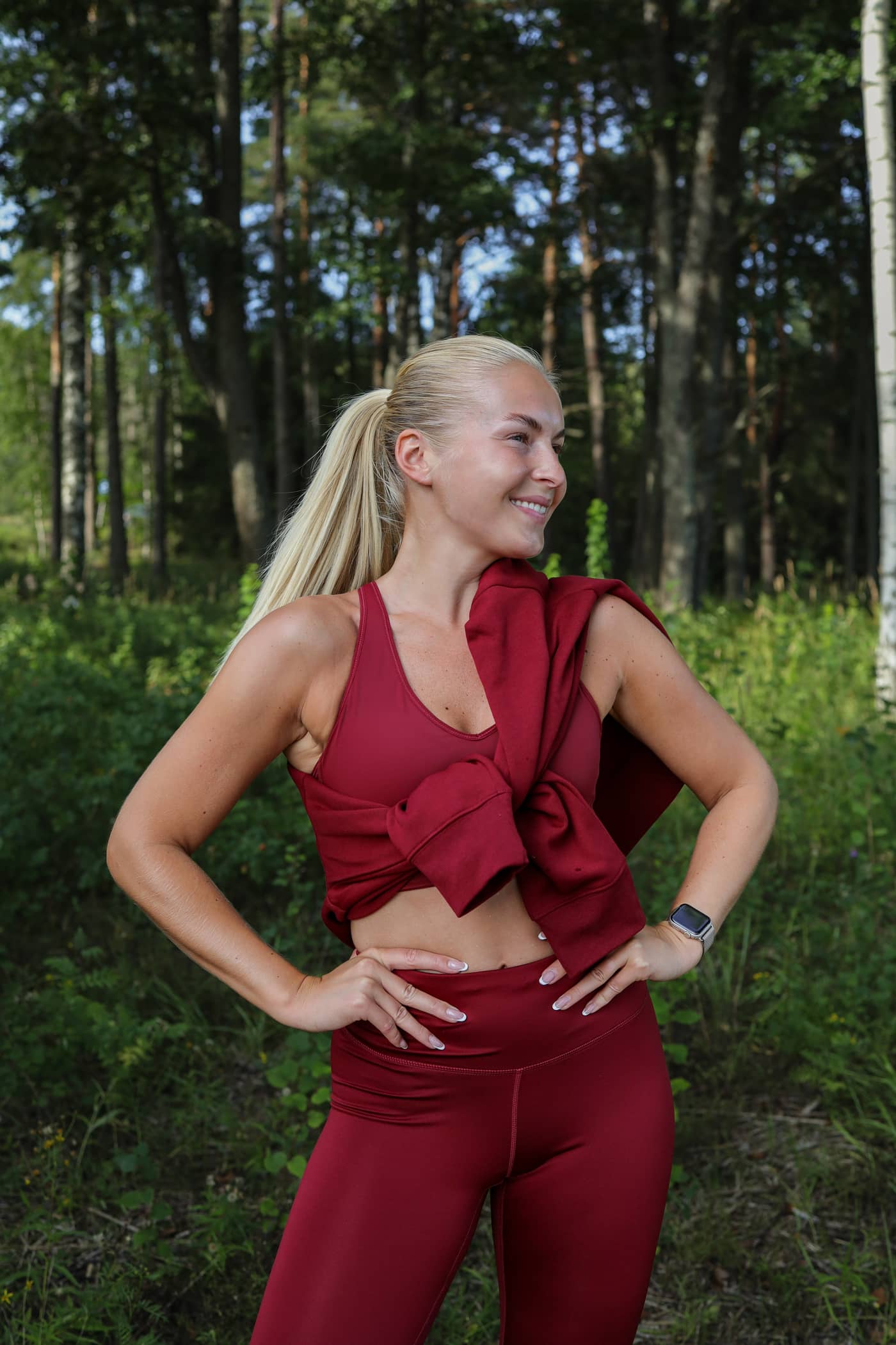 Front view of a woman wearing the Borg Mid V Support in Pomegranate (Red), offering a stylish fit for training outdoors. - Image 1