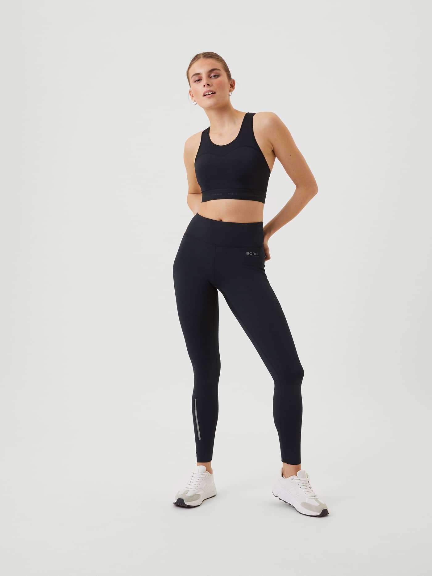 Full-body front view of a woman wearing the slim-fit Borg Running Winter Tights in Black Beauty (Black). - Image 1
