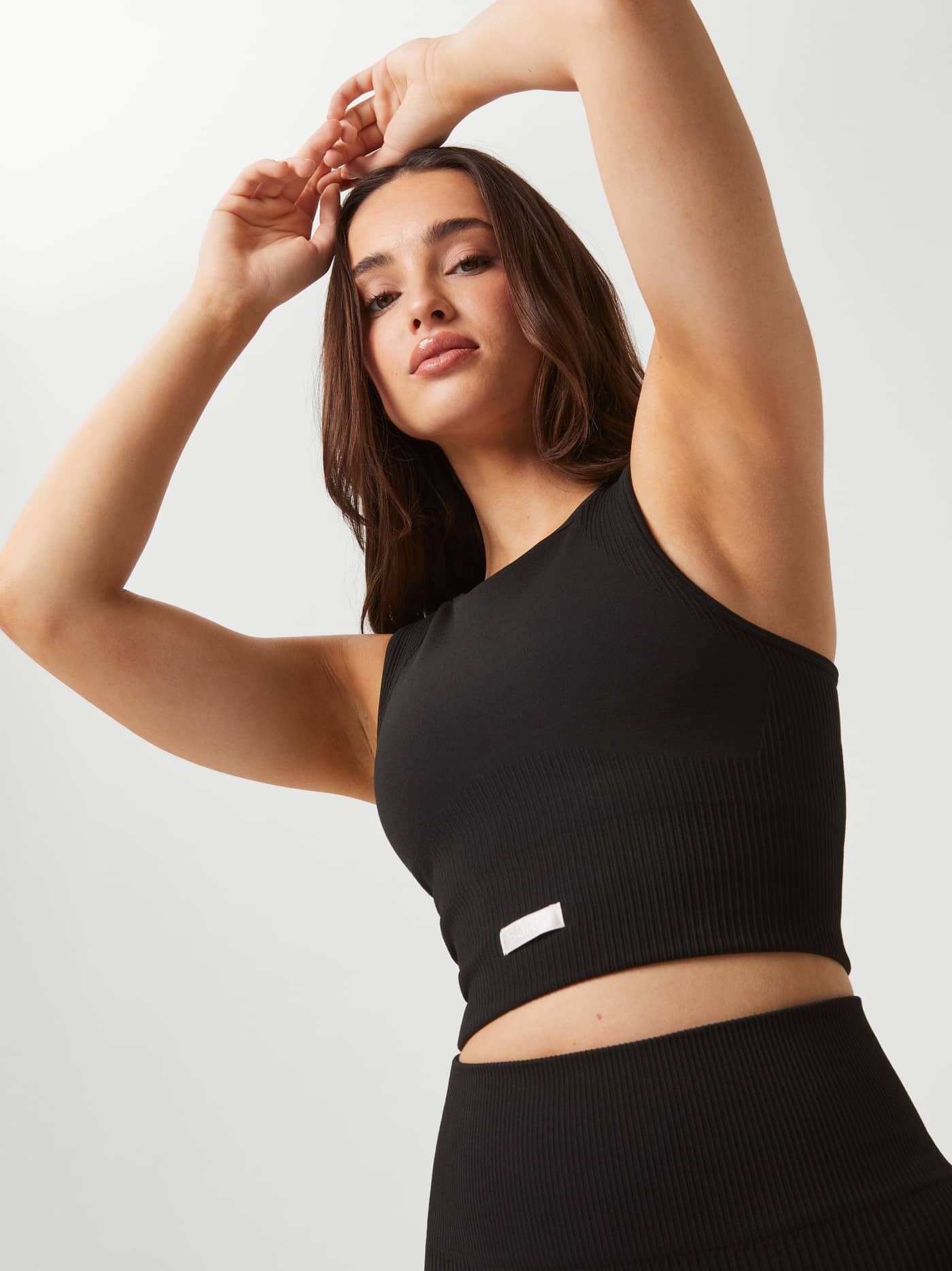 Black Studio Seamless Bralette with a rib-knitted seamless construction and white logo for a stylish training fit. - Image 7