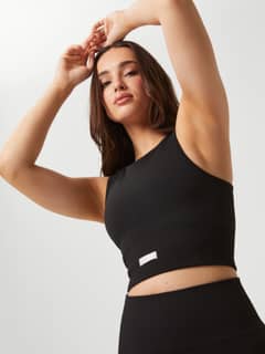 Black Studio Seamless Bralette with a rib-knitted seamless construction and white logo for a stylish training fit. - Image 7