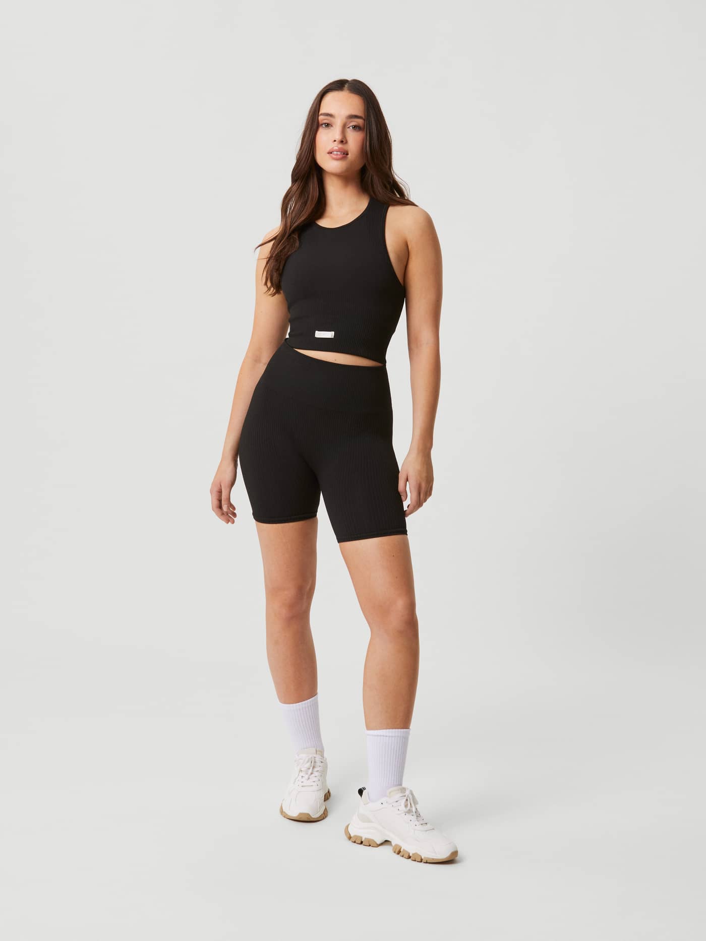 Full-body front view of a model in the rib-knitted Björn Borg Studio Seamless Bralette in Black Beauty (Black) for training. - Image 6