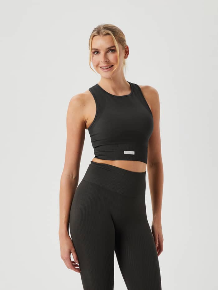 Studio Seamless Bralette in Peat (Groen), een ribgebreide slim-fit trainingstop met wit logo getoond in vooraanzicht.