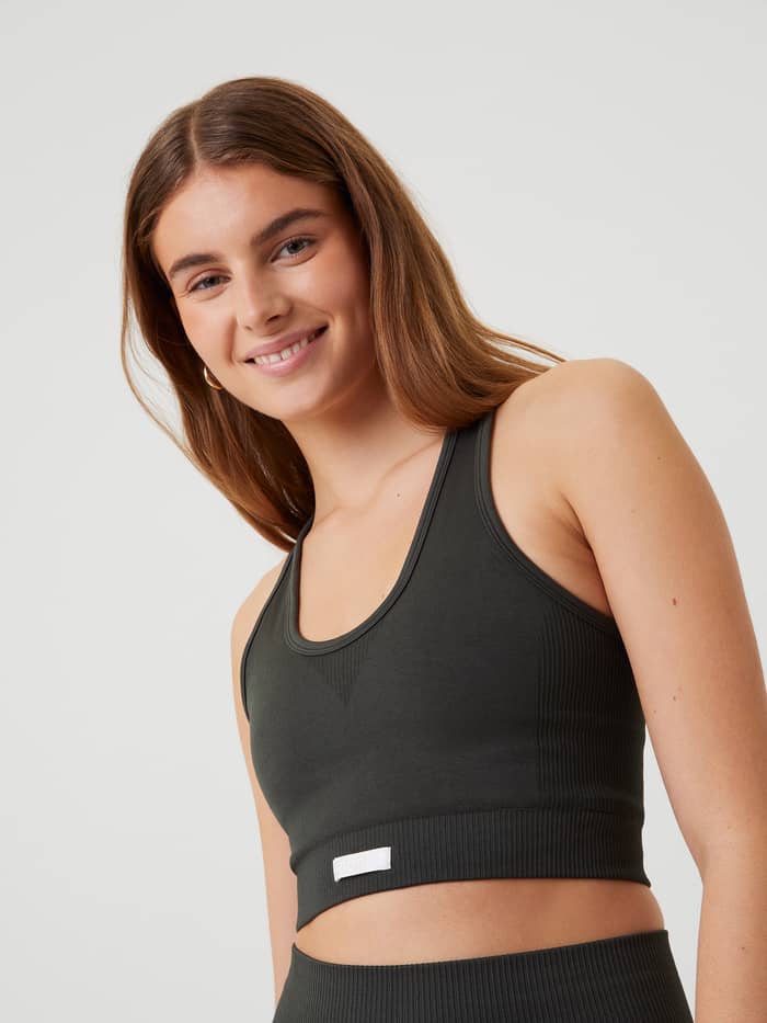 Frau im Björn Borg Studio Low Seamless Bra in Peat (Grün) zum Training mit stylischer Passform und weißem Logo. - Image 2