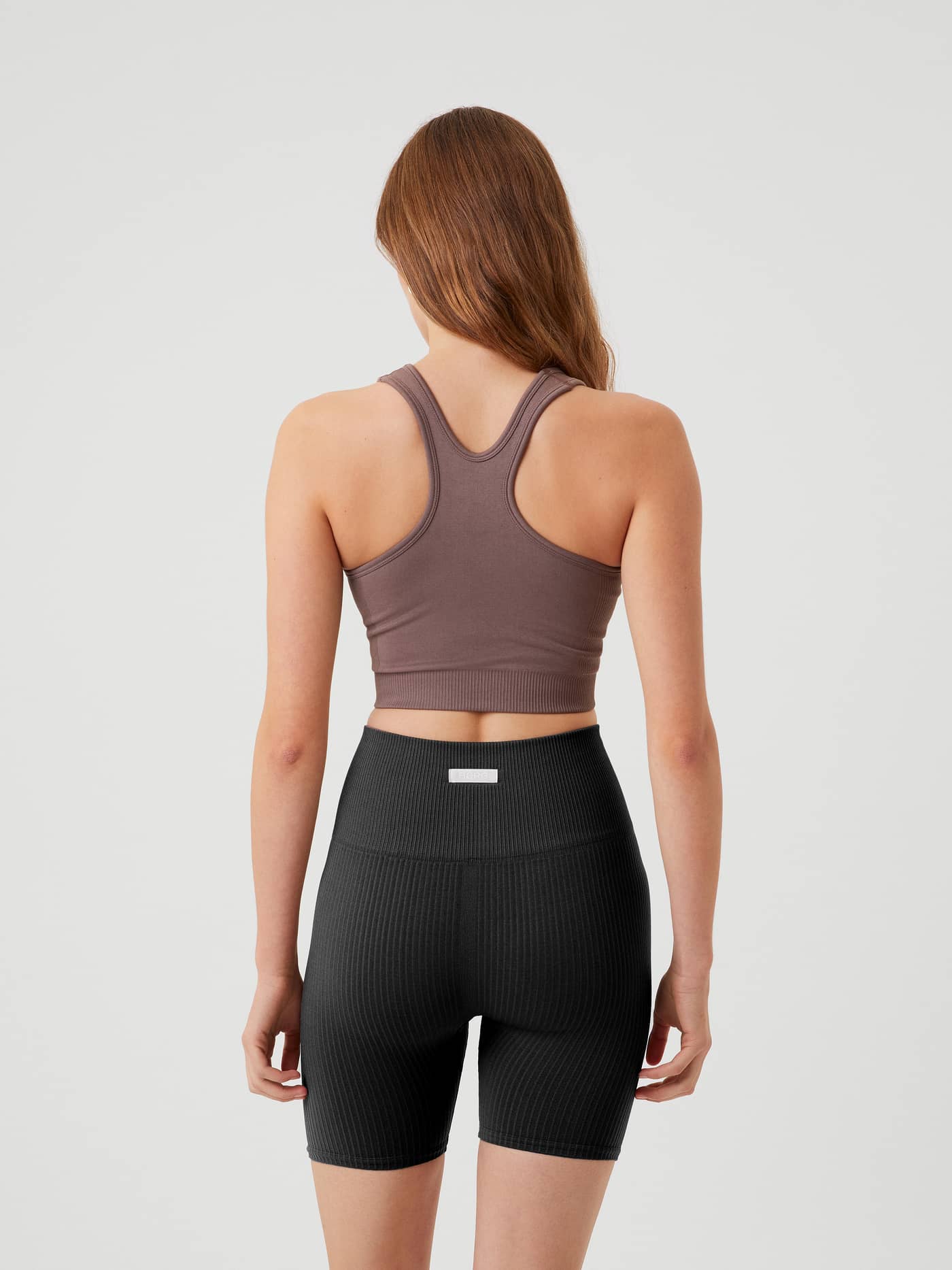 Vue de dos d'une femme portant la Studio Low Seamless Bra en Sparrow (Brun) avec dos nageur pour le training. - Image 3