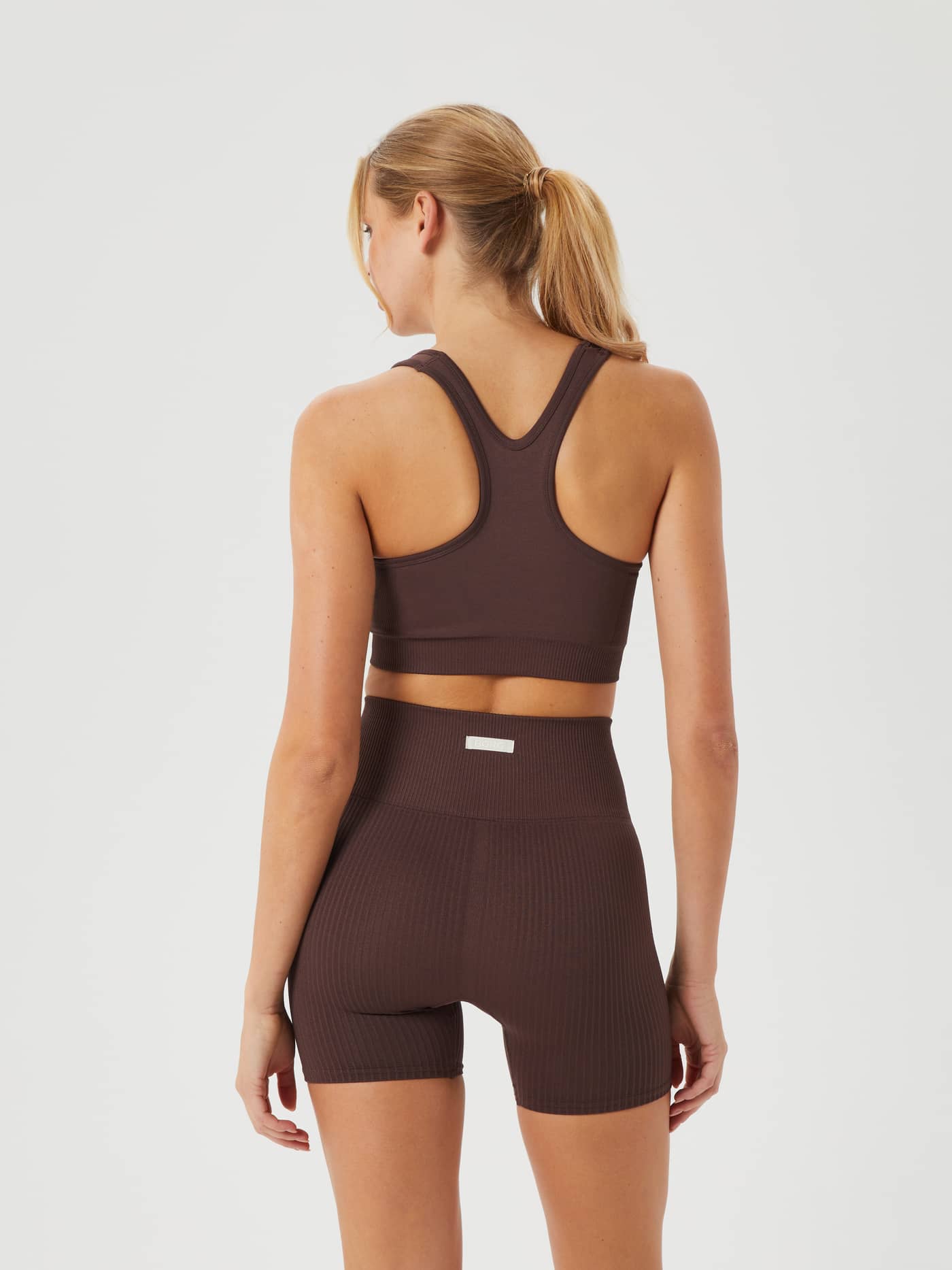 Back view of a woman wearing the Björn Borg Studio Low  Seamless Bra in French Toast (Brown), with a racerback for training. - Image 4