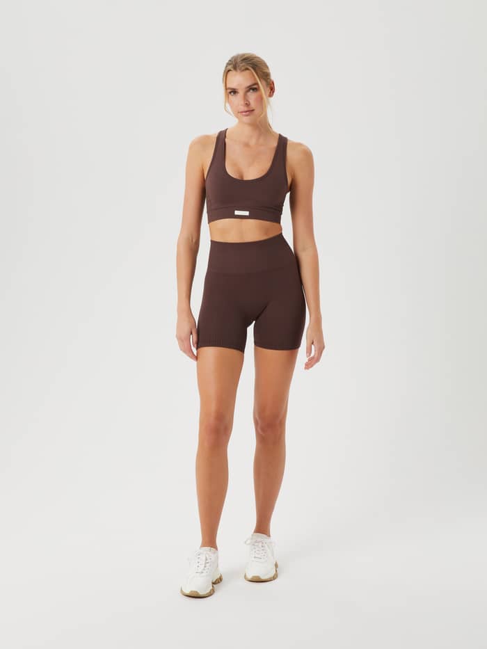 Ganzkörper-Vorderansicht einer Frau im Studio Low Seamless Bra in French Toast (Braun) mit passenden Trainingsshorts. - Image 5
