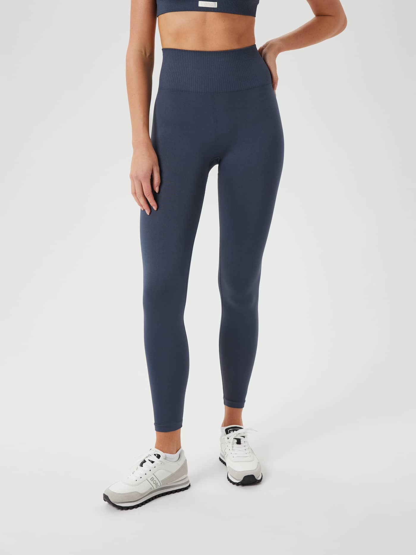 Front view of a model wearing the high-waisted Studio Seamless Light Tights in Midnight Navy (Navy) for training. - Image 2