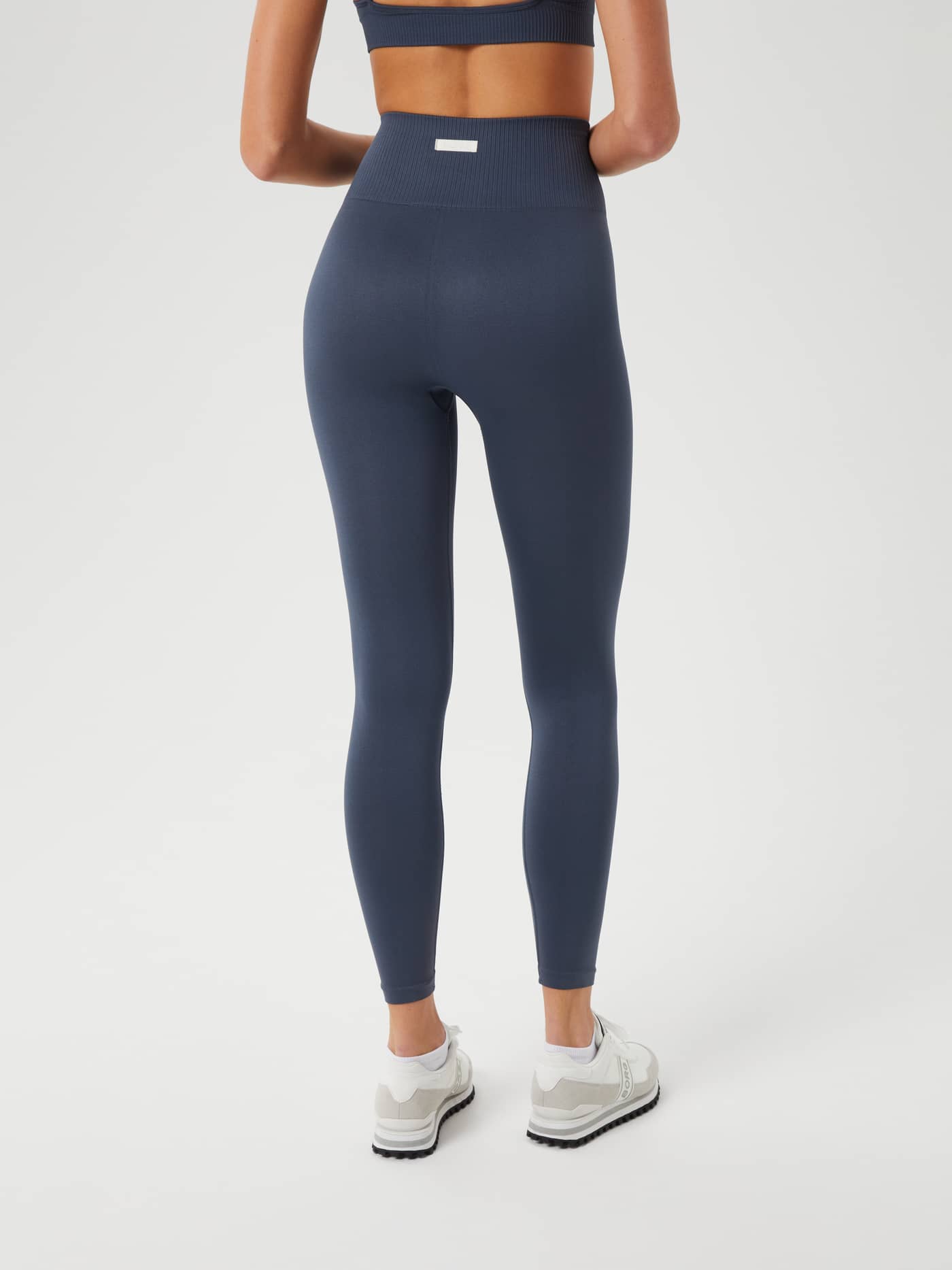 Back view of a model wearing the high-waisted Björn Borg Studio Seamless Light Tights in Midnight Navy (Navy) for training. - Image 3