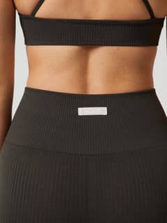 Studio Seamless Rib Shorts i Peat (Grön) sedda bakifrån med hög midja och vit logotyp, perfekta för träning. - Image 8
