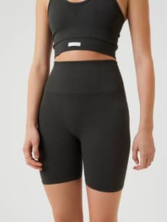 Modell framifrån i Studio Seamless Rib Shorts i Peat (Grön) med hög midja för träning. - Image 2