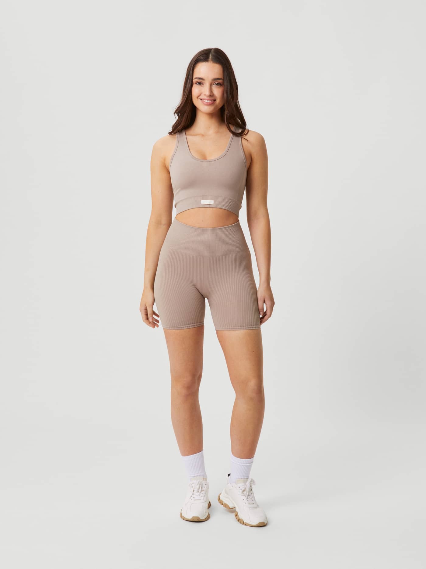 Full-body front view of a woman wearing the Björn Borg Studio Seamless Rib Shorts in Etherea (Beige) for training. - Image 3