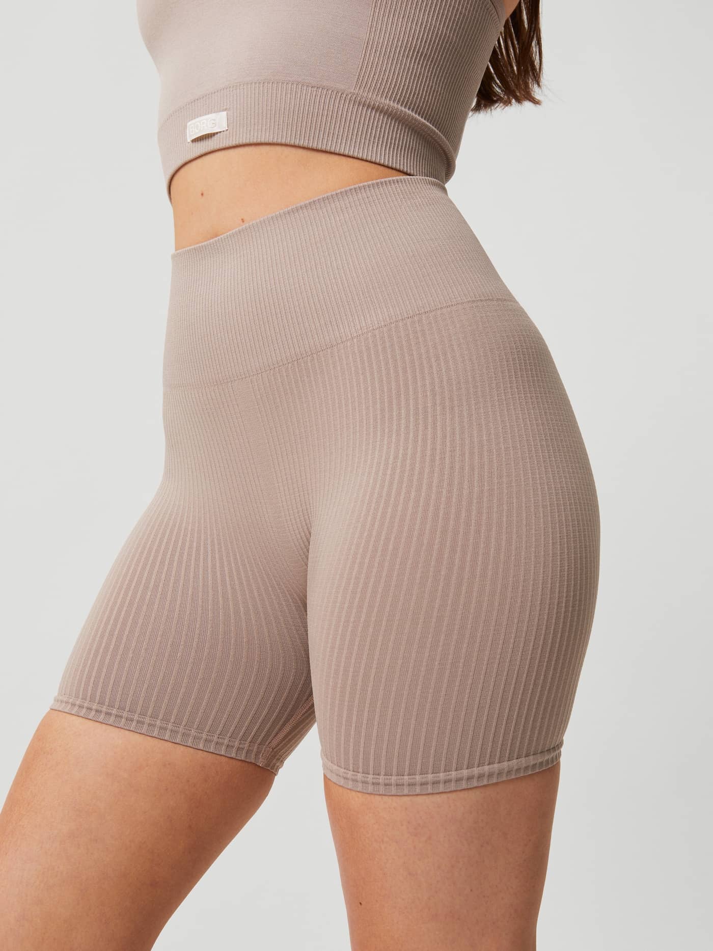 Side view of the Studio Seamless Rib Shorts in Etherea (Beige), featuring a slim fit and rib-knitted texture for training. - Image 1