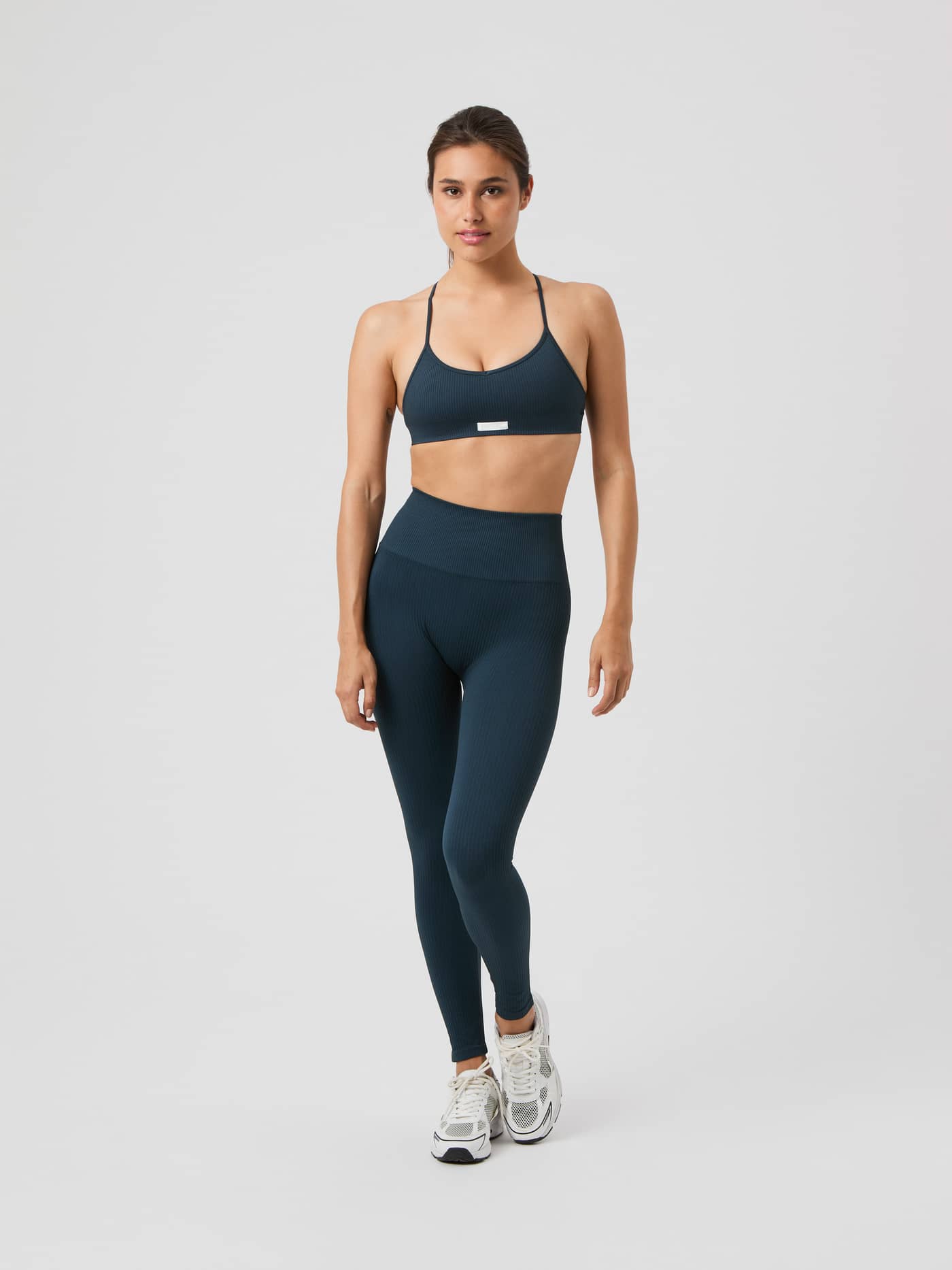 Vue de face d'une femme portant le Studio Seamless Rib Tights en Midnight Navy (Marine) pour l'entraînement. - Image 2