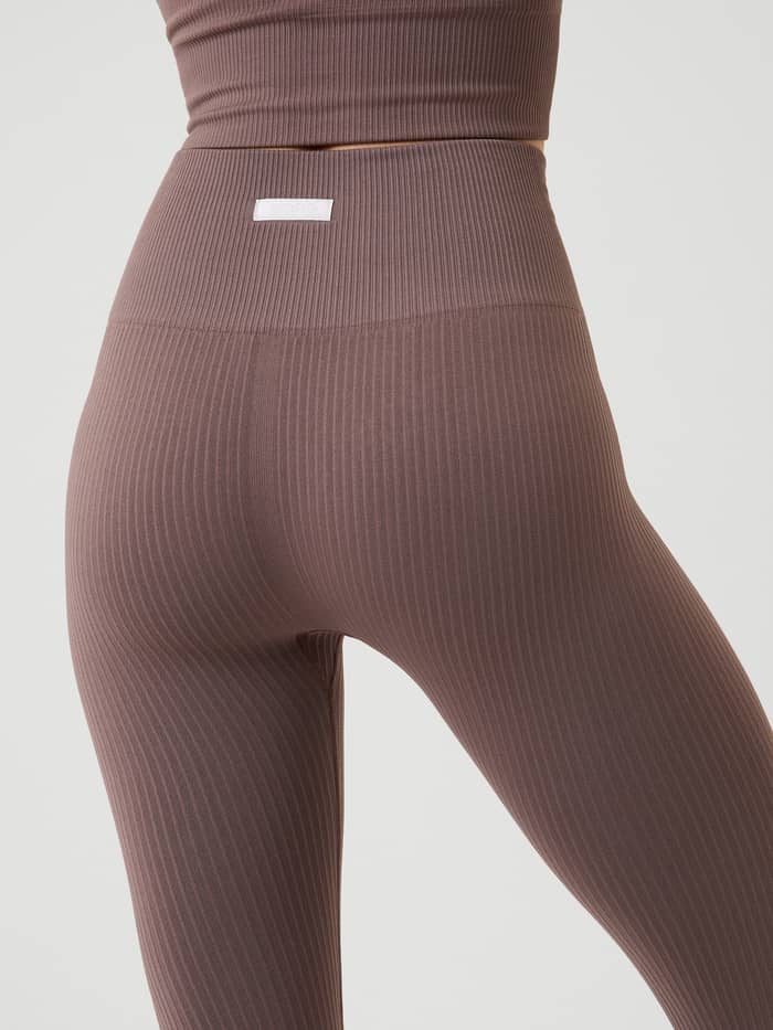 Back view of the Studio Seamless Rib Tights in Sparrow (Brown), showing the rib-knitted texture and small white logo label. - Image 4
