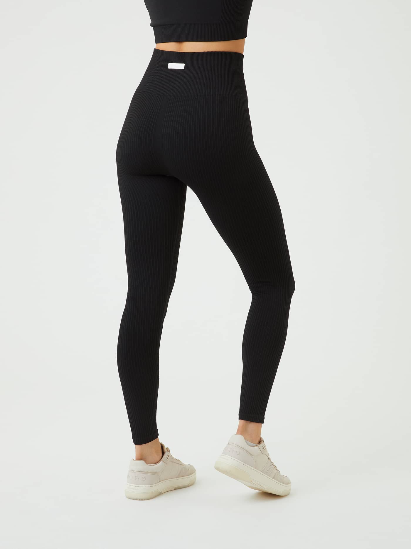 Vista posterior de las Studio Seamless Rib Tights en Black Beauty (Negro) de talle alto y gran ajuste para entrenamiento. - Image 6
