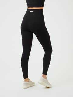 Vista posterior de las Studio Seamless Rib Tights en Black Beauty (Negro) de talle alto y gran ajuste para entrenamiento. - Image 6