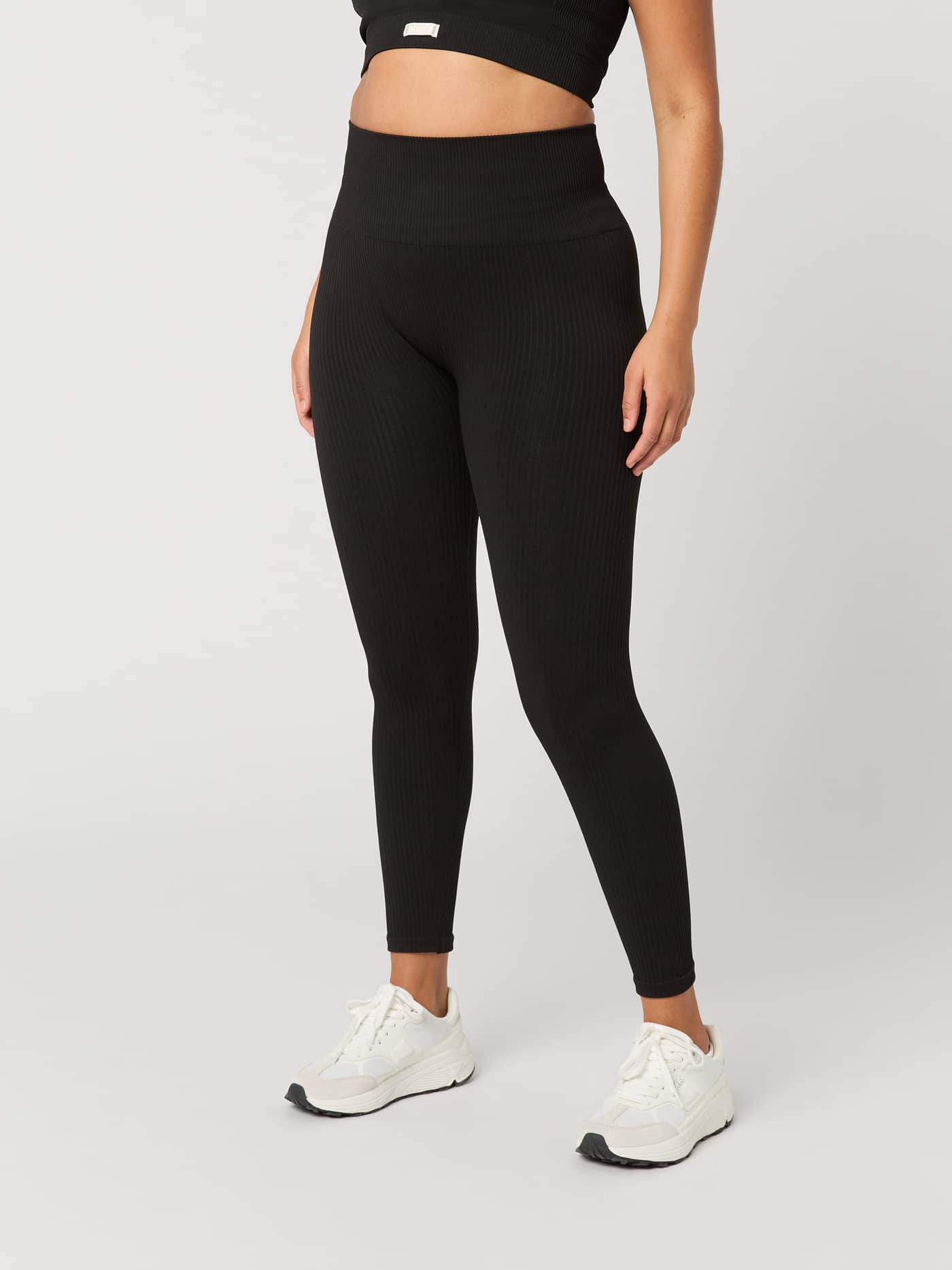 Vista frontal de una modelo con las Studio Seamless Rib Tights en Black Beauty (Negro) con ajuste ceñido para entrenar. - Image 2