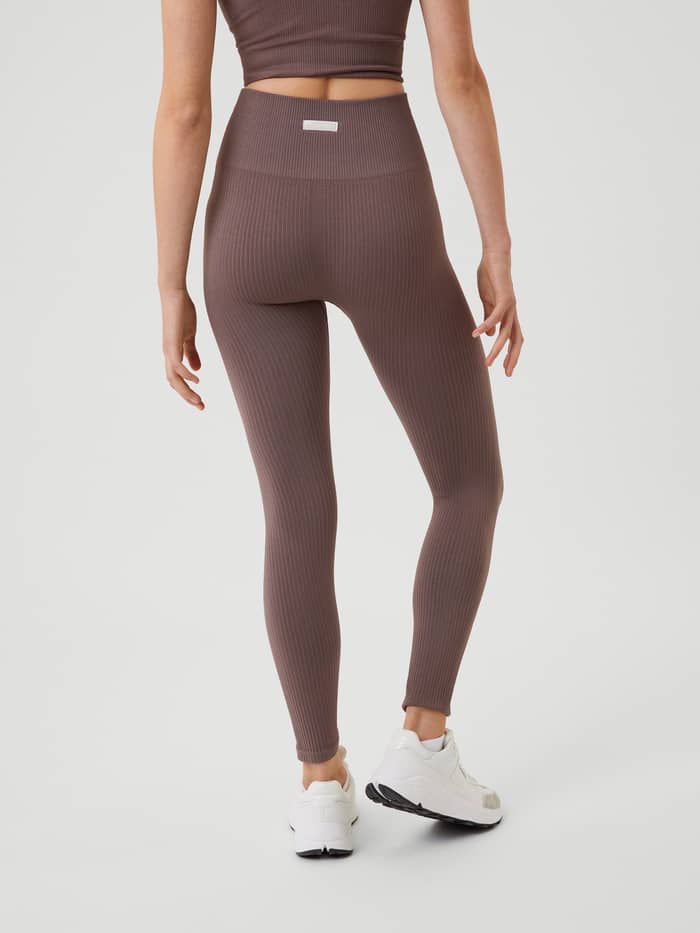 Back view of a model in Sparrow (Brown) Studio Seamless Rib Tights, featuring a high-waisted slim fit for training. - Image 3