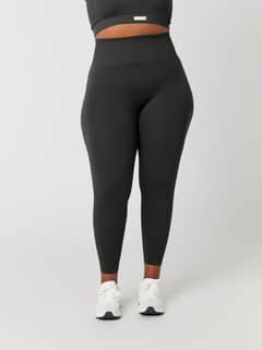 Front view of a model wearing the Studio Seamless Rib Tights in Peat (Green), featuring a high-waisted, slim training fit. - Image 7