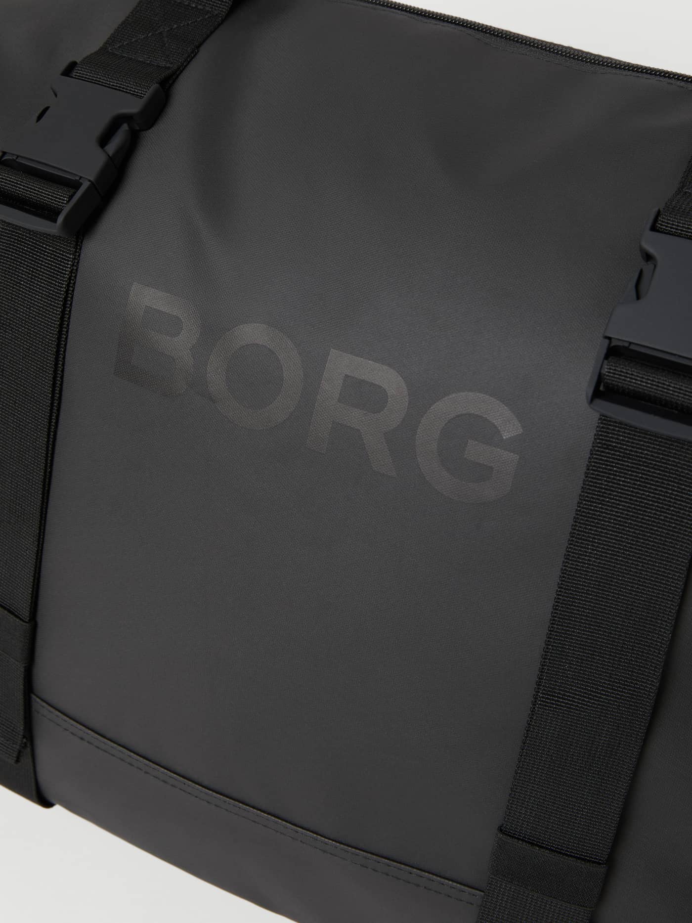 Gros plan du sac d'entraînement Borg Duffle Tote 28L Black Beauty (Noir), logo ton sur ton et finition caoutchouteuse. - Image 3