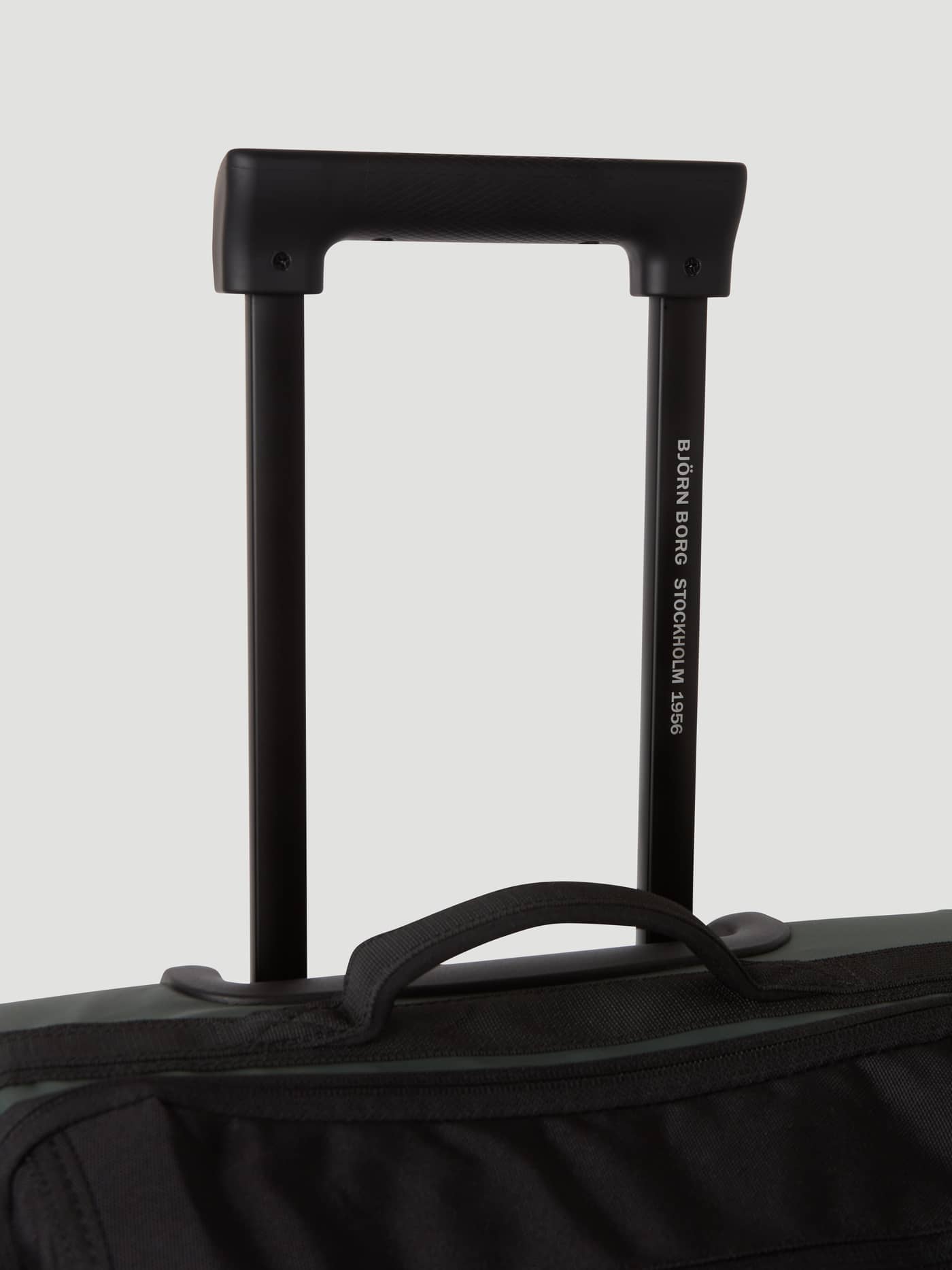 Close-up of the black expandable handle on the Borg Travel Trolley S - 46L in Green, featuring white logo text. - Image 9