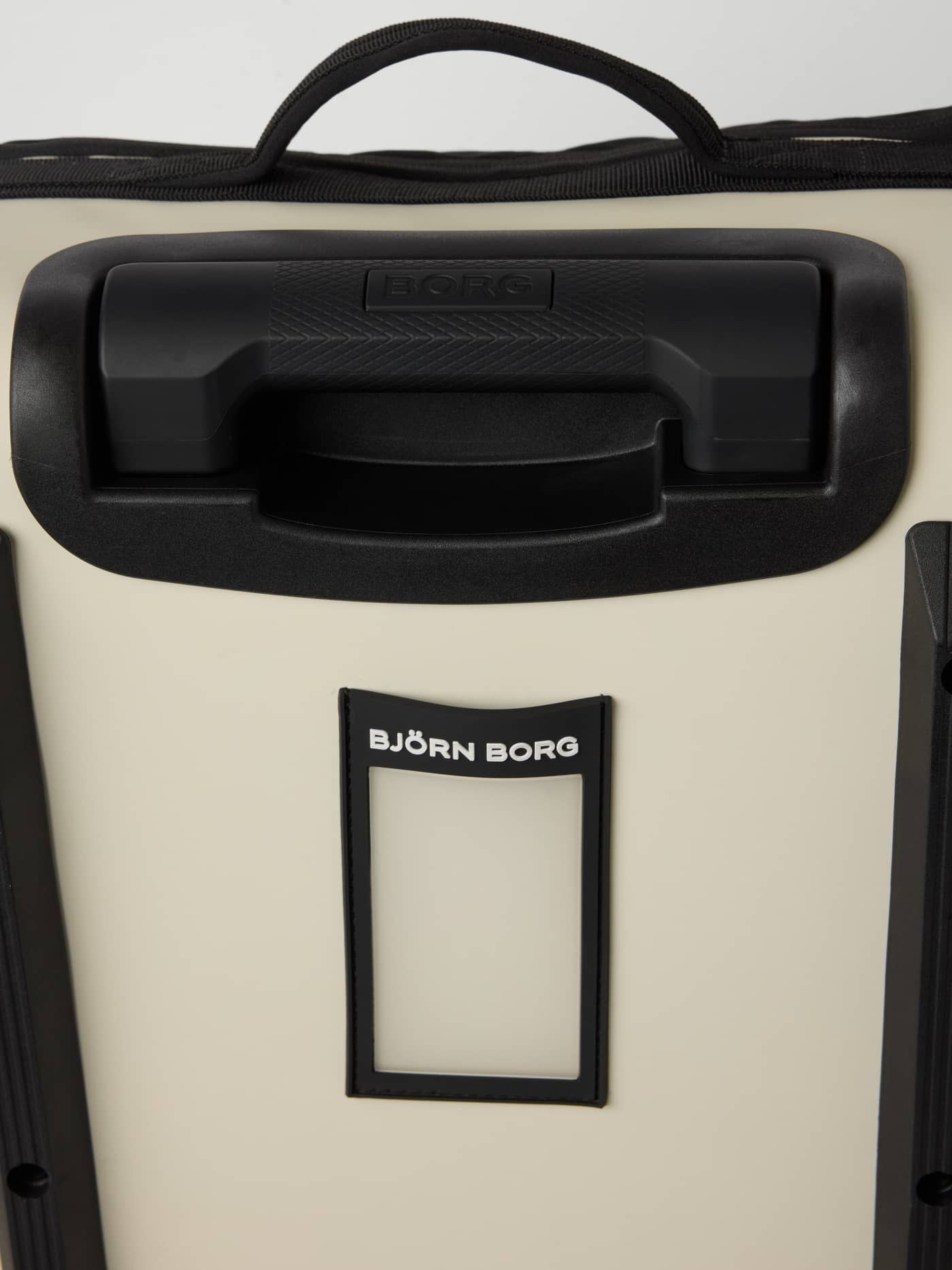 Close-up of the black handles and luggage tag with white logo on the Bone White (White) Borg Travel Trolley S - 46L. - Image 5