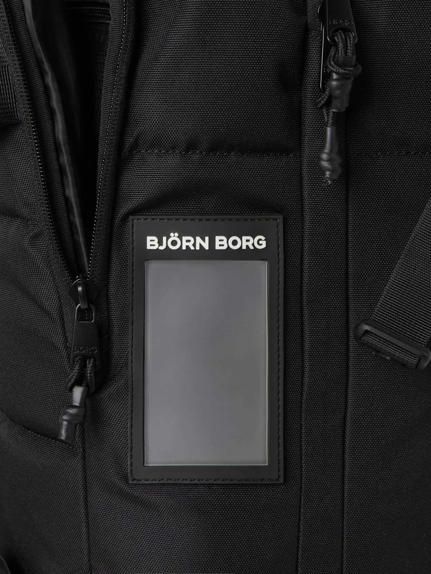 Detailed close-up of the address tag and logo on the green Borg Travel Backpack L - 35L in durable TPE-coated polyester. - Image 6