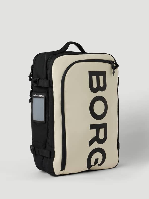 Borg Travel Backpack L - 35L i Bone White (Vit) sedd från sidan med en stor svart logotyp och funktionella sidoremmar.