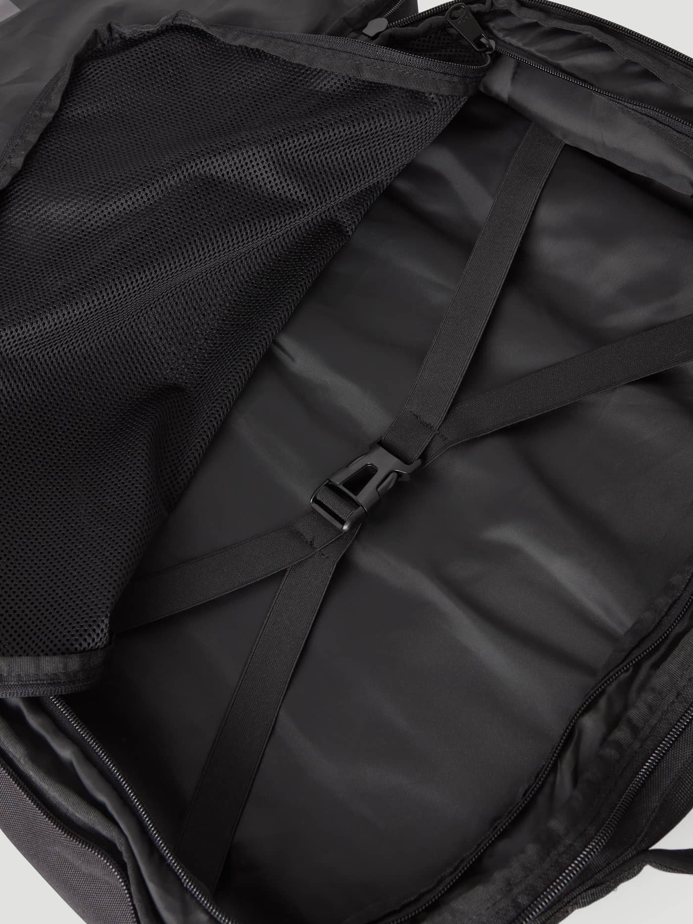 Interior view of the TPE-coated polyester Borg Travel Backpack L - 35L in Green with a black mesh pocket and buckle strap. - Image 3